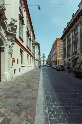 an empty city street with buildings and cars on it at Jana Apartments in Kraków