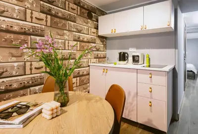 a kitchen with a table with a vase of flowers at Jana Apartments in Kraków