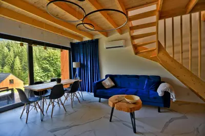 two beds in a room with white walls and wooden floors at Gwiazda Mogielicy basen & balia, sauna in Słopnice