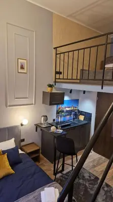a room with a bunk bed and a kitchen with a desk at Amazing Cracow Apartments in Kraków