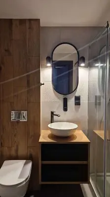 a bathroom with a sink and a toilet and a mirror at Amazing Cracow Apartments in Kraków