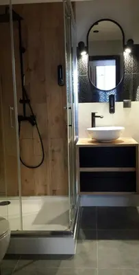 a bathroom with a glass shower and a sink at Amazing Cracow Apartments in Kraków