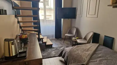 a room with a bed and a spiral staircase at Amazing Cracow Apartments in Kraków