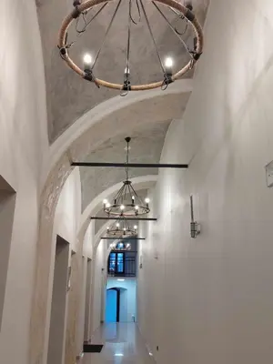 a hallway in a building with a chandelier at Amazing Cracow Apartments in Kraków