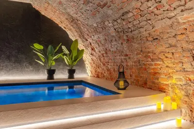 a swimming pool in the middle of a room with a brick wall at Muse by StayLab in Kraków