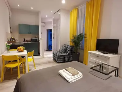a room with a bed and a table and a kitchen at L-2 Kraków Center Studio O&P ApartFamily in Kraków