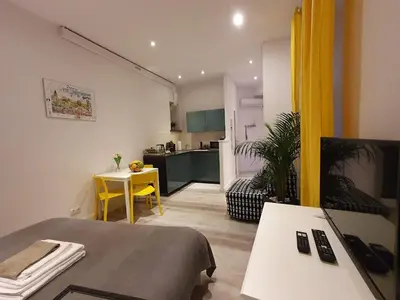 a room with a bed and a table and a kitchen at L-2 Kraków Center Studio O&P ApartFamily in Kraków