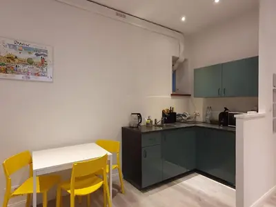 a kitchen with a table and yellow chairs in it at L-2 Kraków Center Studio O&P ApartFamily in Kraków
