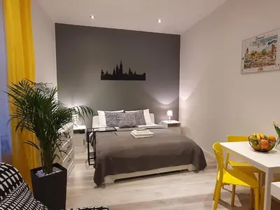 a bedroom with a bed and a table and chairs at L-2 Kraków Center Studio O&P ApartFamily in Kraków