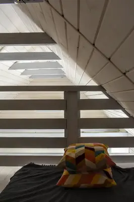 a bed with a pillow in a room with windows at Domek na Winnicy Zagrabie in Rybna