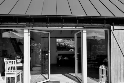 a screened in porch with two chairs and an umbrella at Domek na Winnicy Zagrabie in Rybna