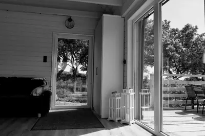 a screened in porch with a couch and a sliding glass door at Domek na Winnicy Zagrabie in Rybna