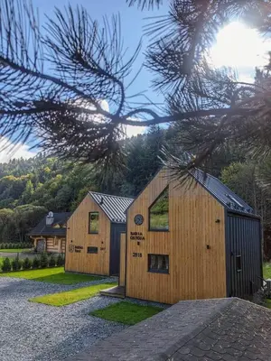 a couple of wooden buildings in a yard at Babia Ostoja - domek z balią i sauną in Zawoja