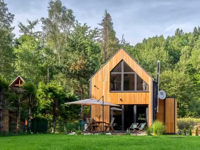 a small wooden house in a field of grass at Babia Ostoja - domek z balią i sauną in Zawoja
