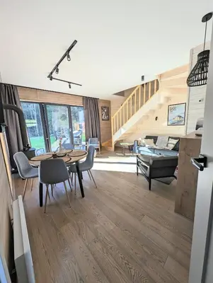 a living room with a table and chairs and a staircase at Babia Ostoja - domek z balią i sauną in Zawoja