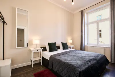 a bedroom with a large bed and a window at Piasek Elegant Apartments in Kraków