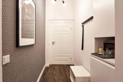 a white hallway with a white door and a kitchen at Piasek Elegant Apartments in Kraków