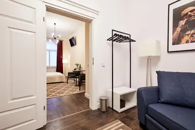 a living room with a blue couch and a desk at Piasek Elegant Apartments in Kraków