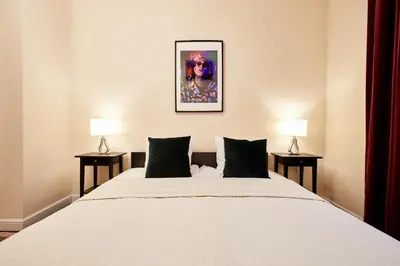 a bedroom with a large white bed with two lamps at Piasek Elegant Apartments in Kraków