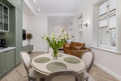 a dining room with a table with a vase of flowers at Apartament w Centrum Krakowa 106 in Kraków