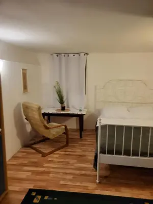 a bedroom with a bed and a chair and a desk at Grzegorzecka Room nr 1 in Kraków