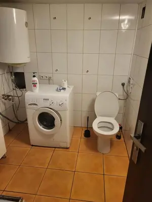 a small bathroom with a toilet and a washing machine at Grzegorzecka Room nr 1 in Kraków