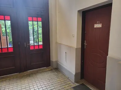 two wooden doors in a room with a tiled floor at Grzegorzecka Room nr 1 in Kraków