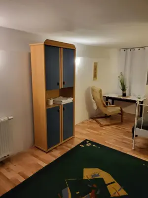 a living room with a cabinet and a desk at Grzegorzecka Room nr 1 in Kraków