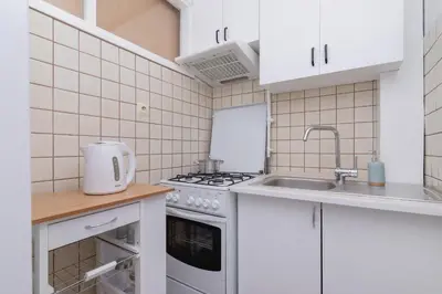 a kitchen with white cabinets and a sink and a stove at Comfy & Bright Studio Wielicka in Krakow by Noclegi Renters in Kraków