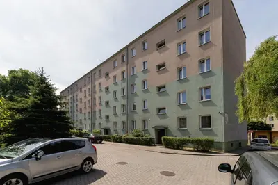 a large building with cars parked in front of it at Comfy & Bright Studio Wielicka in Krakow by Noclegi Renters in Kraków