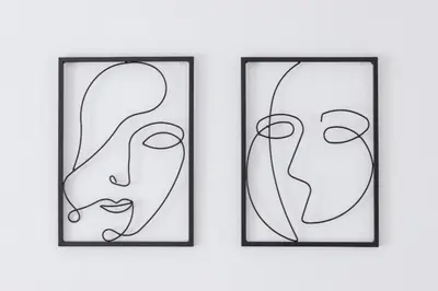 two framed art prints of two faces on a wall at Comfy & Bright Studio Wielicka in Krakow by Noclegi Renters in Kraków