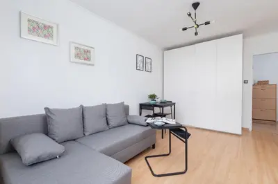 a living room with a couch and a table at Comfy & Bright Studio Wielicka in Krakow by Noclegi Renters in Kraków