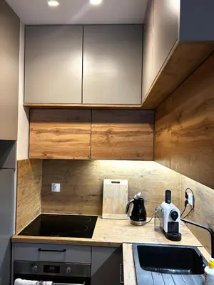 a kitchen with wooden cabinets and a sink at Apartament Novo 46 in Kraków