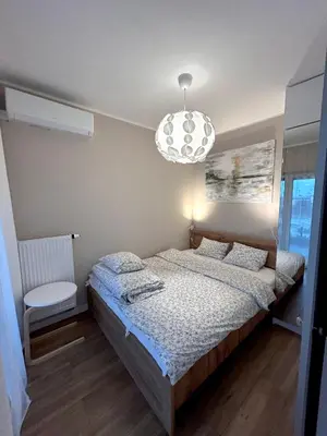 a bedroom with a bed and a chandelier at Apartament Novo 46 in Kraków