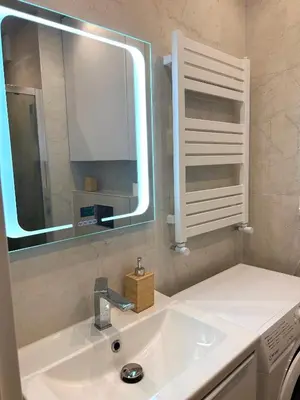 a bathroom with a sink and a mirror at Apartament Novo 46 in Kraków