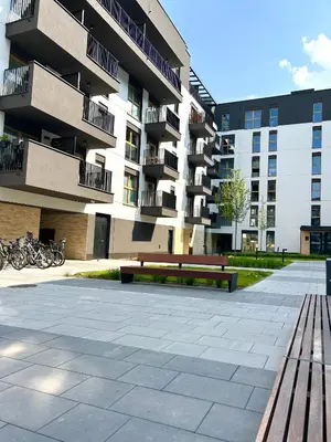 a large apartment building with a bench in front of it at Apartament Novo 46 in Kraków