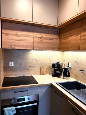 a kitchen with wooden cabinets and a stove top oven at Apartament Novo 46 in Kraków