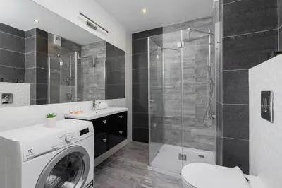 a bathroom with a washing machine and a shower at Zabłocie Pet-friendly Ślusarska Apartment by Noclegi Renters in Kraków