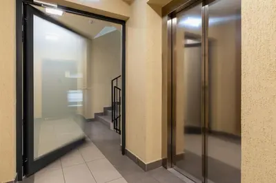 a hallway with a glass door in a building at Zabłocie Pet-friendly Ślusarska Apartment by Noclegi Renters in Kraków