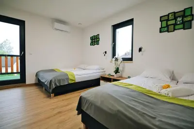 a bedroom with two beds and two windows at Noclegi u Szymonków Zator Przeciszów in Zator