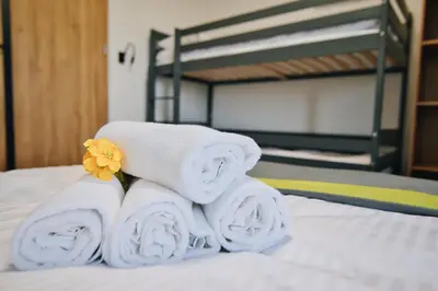 a pile of towels sitting on top of a bed at Noclegi u Szymonków Zator Przeciszów in Zator