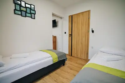a bedroom with two beds and a door at Noclegi u Szymonków Zator Przeciszów in Zator