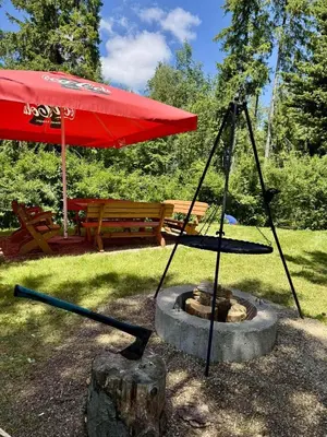 a red umbrella and a fire pit in a park at Domek pod Modrzewiem in Nowy Targ