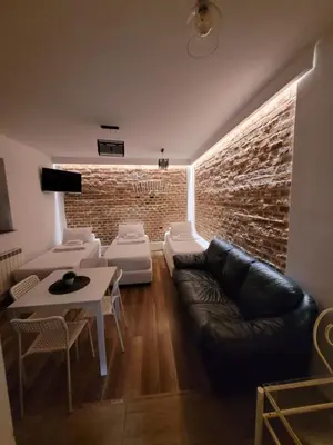 a living room with a couch and a brick wall at Apartamenty Kącik in Kraków