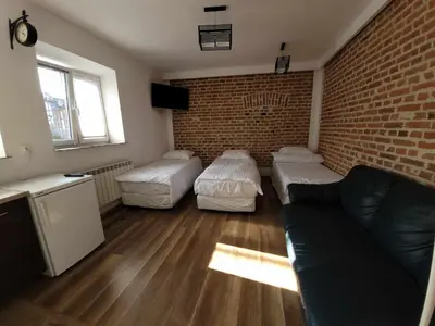 a living room with a couch and a brick wall at Apartamenty Kącik in Kraków