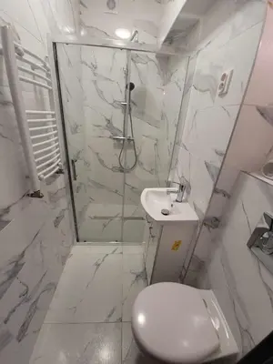 a bathroom with a shower and a toilet and a sink at Apartamenty Kącik in Kraków