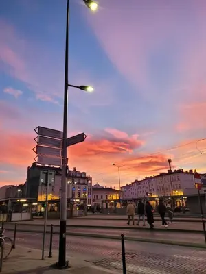 a group of people walking down a street at sunset at Apartamenty Kącik in Kraków