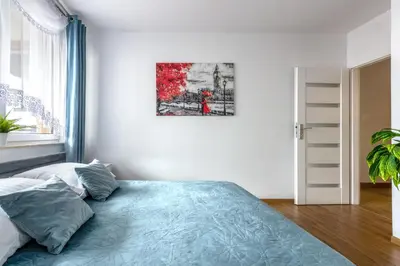 a bedroom with a bed and a painting on the wall at Apartment BLUE PEARL 2 rooms Down Town 4 persons balcony free parking in Kraków