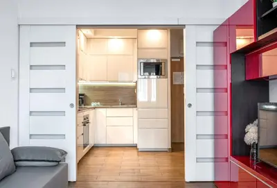 a room with a sliding door leading into a kitchen at Apartment BLUE PEARL 2 rooms Down Town 4 persons balcony free parking in Kraków
