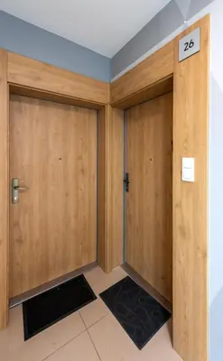 two wooden doors in a room with a tile floor at Apartment BLUE PEARL 2 rooms Down Town 4 persons balcony free parking in Kraków